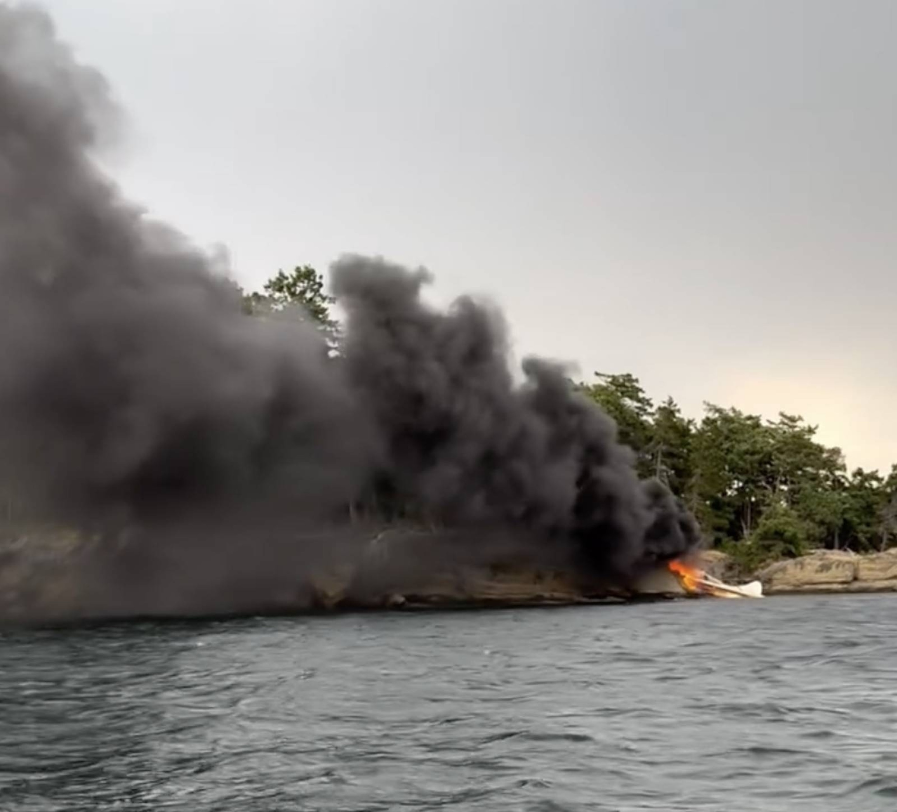 A still photo from a video posted to Facebook shows a Kenmore Air plane that caught fire after crashing off the coast of Washington state.Monica Scott / Facebook