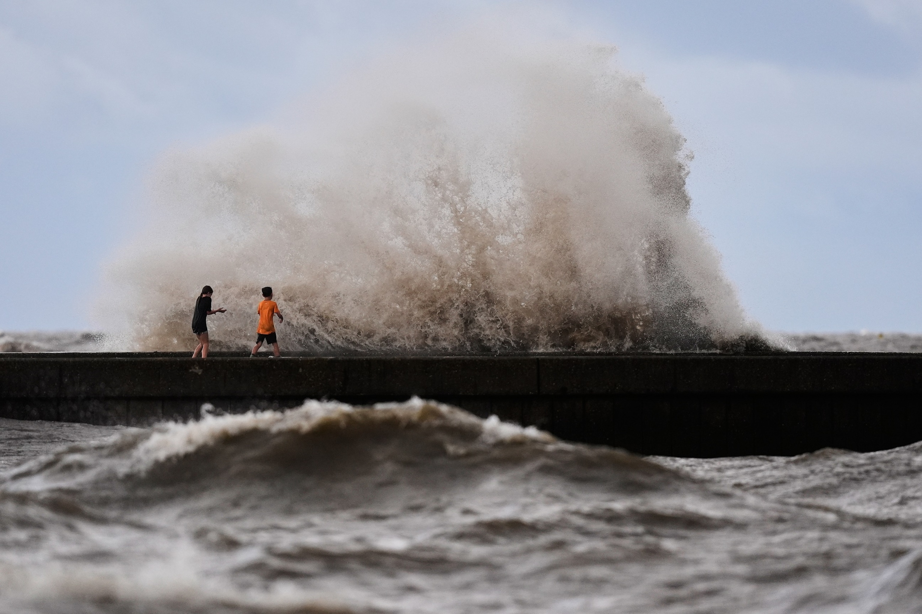 Children play near breaking waves on West End Pier on Lake Pontchartrain as Tropical Storm Bertha approaches the Louisiana Coast Wednesday, July 22, 2026, in New Orleans.Gerald Herbert/AP Photo