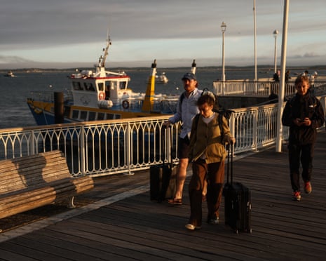 Holidaymakers from Lege-Cap-Ferret carry their belongings along the pier upon their arrival in Arcachon during an evacuation operation of the entire Cap-Ferret peninsula in southwestern France.Photograph: Romain Perrocheau/AFP/Getty Images