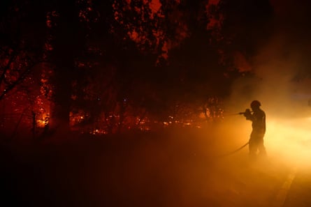 A firefighter battles flames in Cap Ferret.Photograph: Stéphane Mahé/Reuters