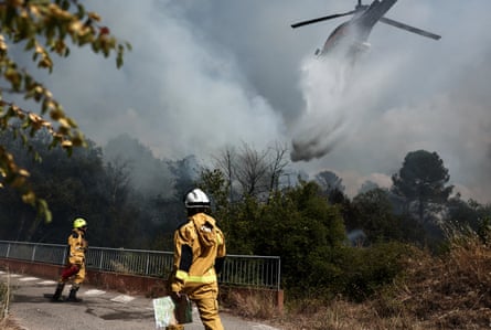 A helicopter drops water over a burning area as a wildfire flares up again in Pontevès, south-east France.Photograph: Thibaud Moritz/AFP/Getty