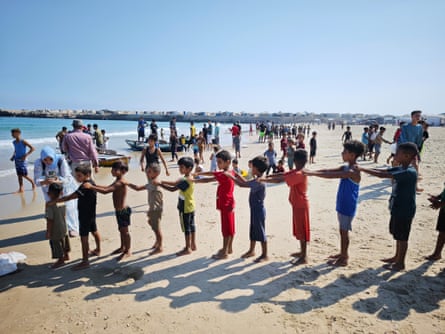 Children form a chain before getting into the water