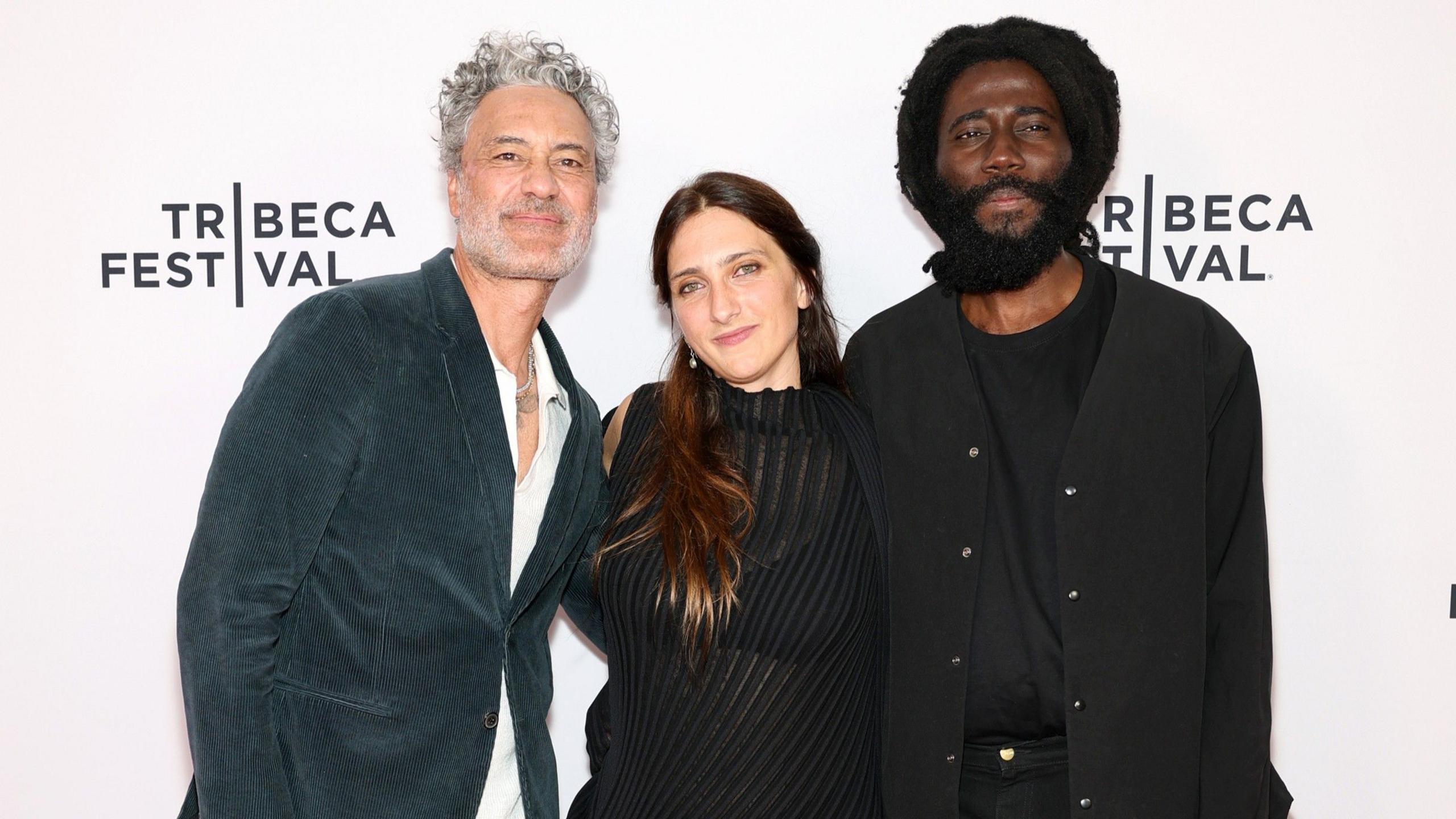 Image caption,Former New Bell prisoner Steve Happi (R) directed the documentary with Dione Roach (C) and Taika Waititi (L) was an executive producer