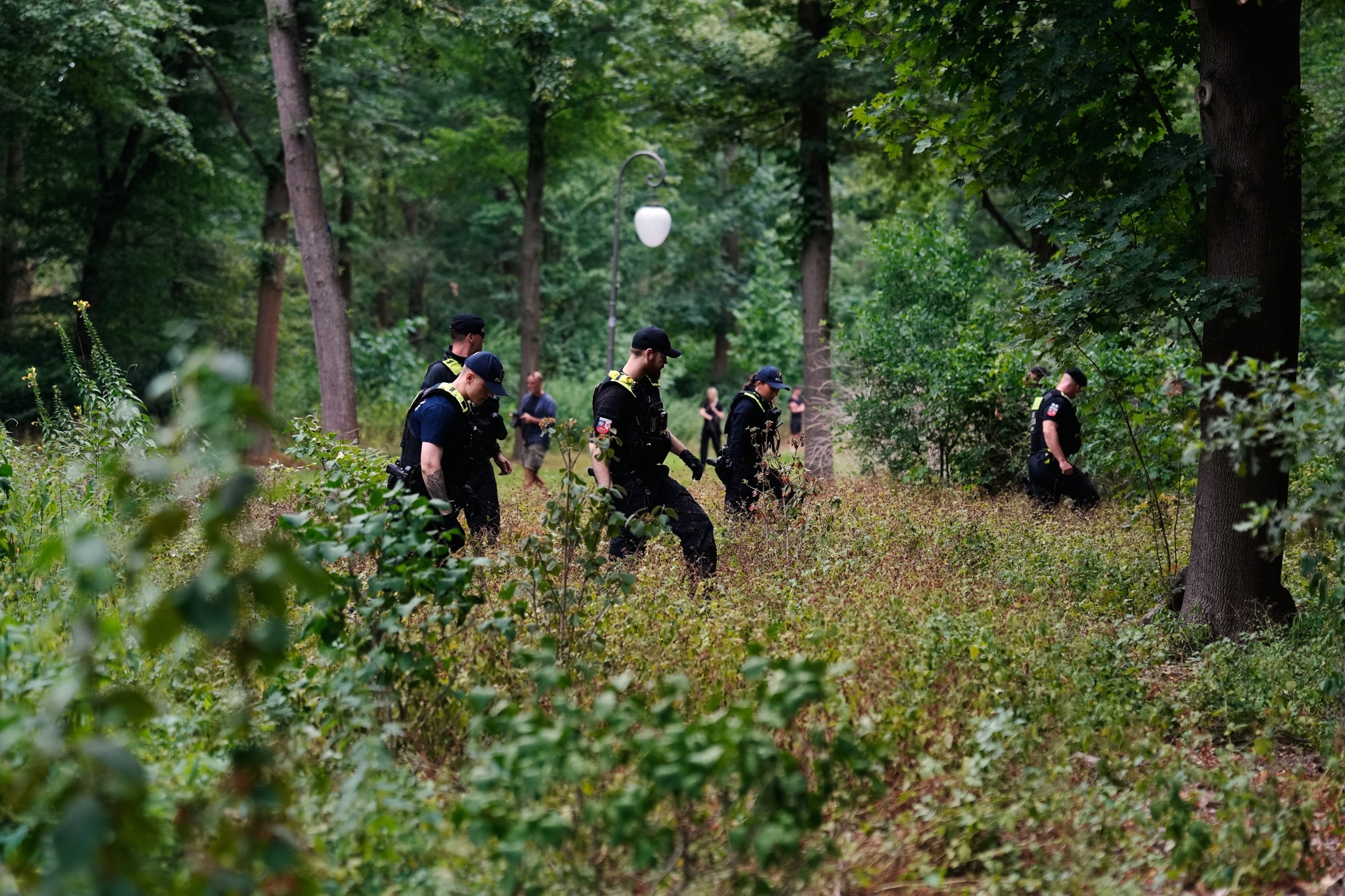 A police officer searches in the Tiergarten Park near the scene where a vehicle rammed into a crowd near the Pride March in Berlin, Germany, Sunday, July 26, 2026.Markus Schreiber/AP Photo
