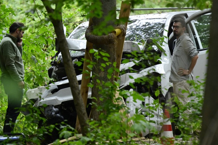 Police officers inspect the car that allegedly was driven into people, killing one person and injuring dozens more before crashing on a tree in the Tiergarten park on the outskirts of the Christopher Street Day parade in Berlin.John Macdougall / AFP via Getty Images