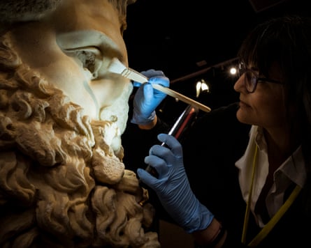A conservator prepares an ancient sculpture of the head of Zeus for exhibition in Melbourne, AustraliaPhotograph: Christopher Hopkins/The Guardian