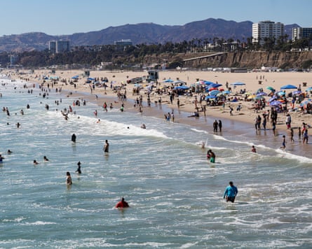 People enjoy the beach along the Santa Monica Pier in Santa Monica, California, on 21 July amid a heatwave.Photograph: Chris Torres/EPA