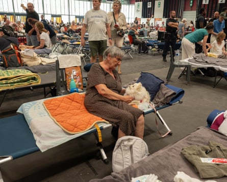 A woman and her dog at the emergency shelter.Photograph: Caroline Blumberg/AP