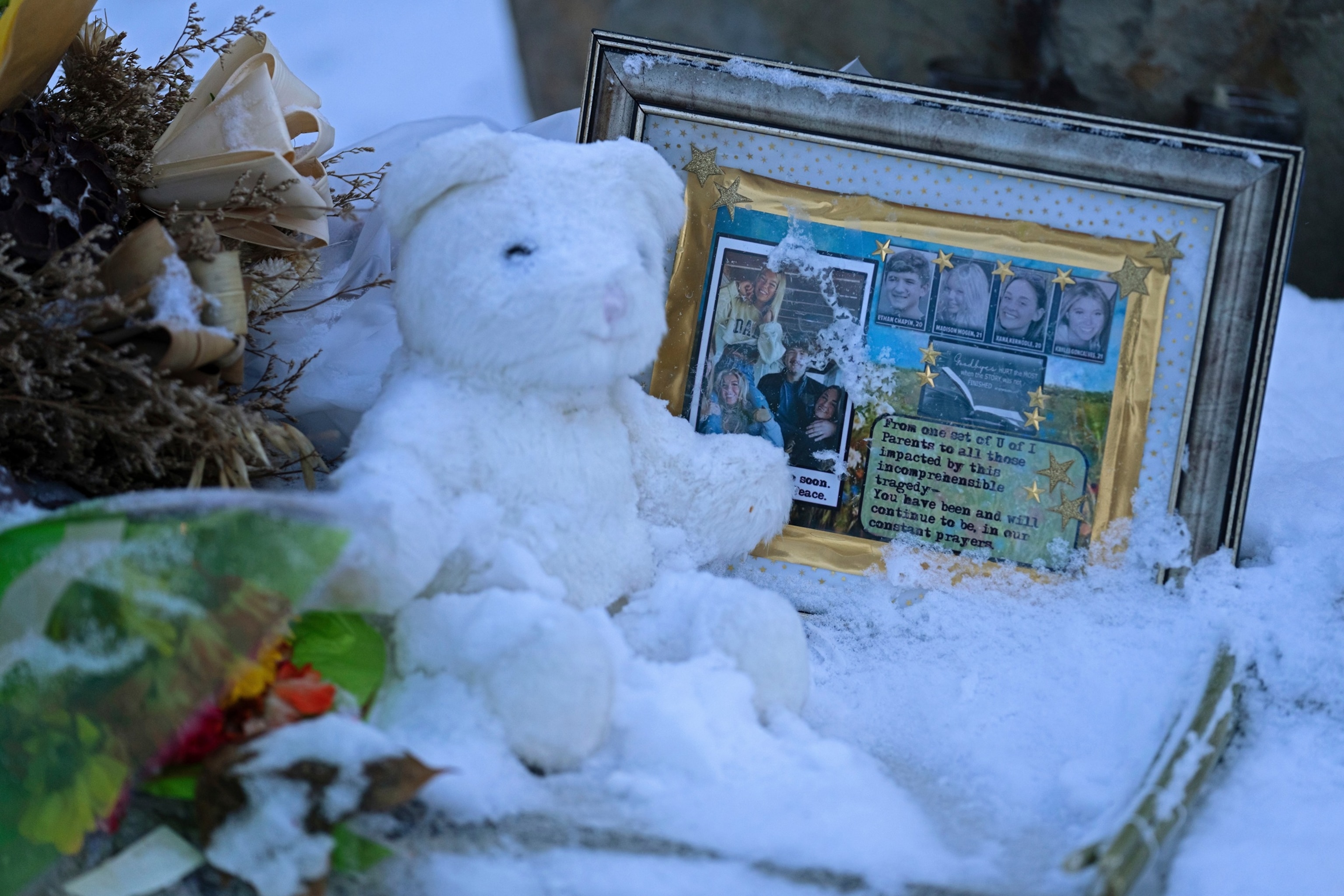 Flowers, a stuffed animal, and a framed image featuring the photos of the four people found dead at a house on Nov. 13, 2022 in Moscow, Idaho, rest in the snow in front of the house on Tuesday, Nov. 29, 2022.Ted S. Warren/AP