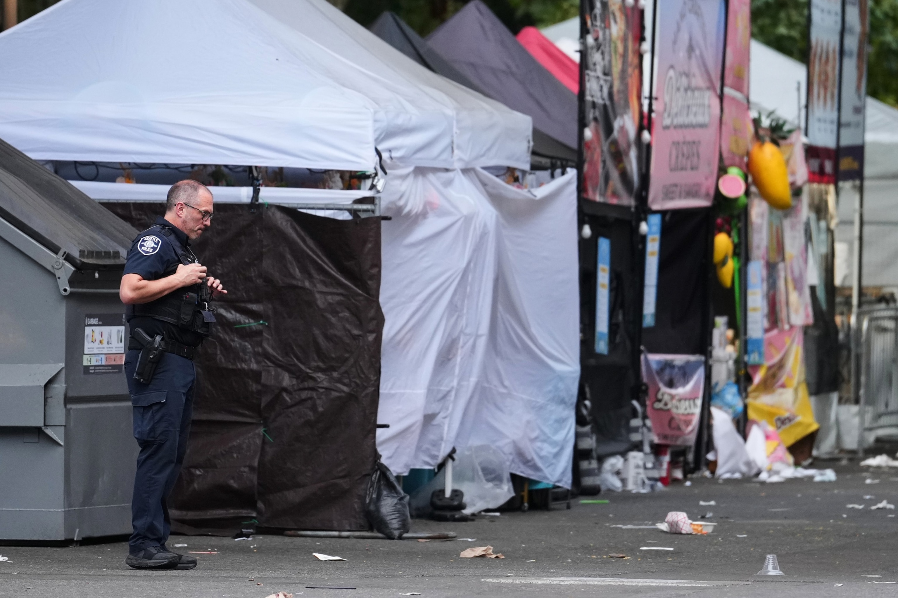 A Seattle Police officer looks down while stationed at the scene after a shooting at Seattle Center during the Bite of Seattle food festival, July 26, 2026, in Seattle.Lindsey Wasson/AP Photo