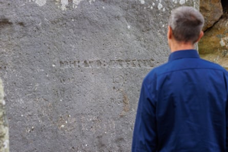 The Guardian’s Steven Morris examines an inscription on one of the stones at Stonehenge, which first started charging for visits 125 years ago.Photograph: Sam Frost/The Guardian