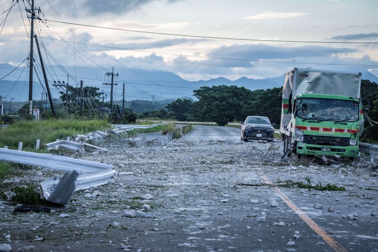 A damaged truck and car are seen on a debris-covered road after an explosion at the Aeon mall in Kashima, Japan.Yuichi Yamazaki / AFP via Getty Images