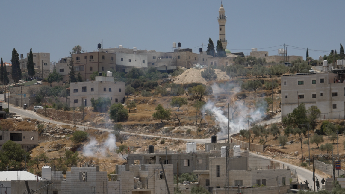 Image caption,Clouds of tear gas fired by Israeli troops rise from the streets of al-Mughayyir