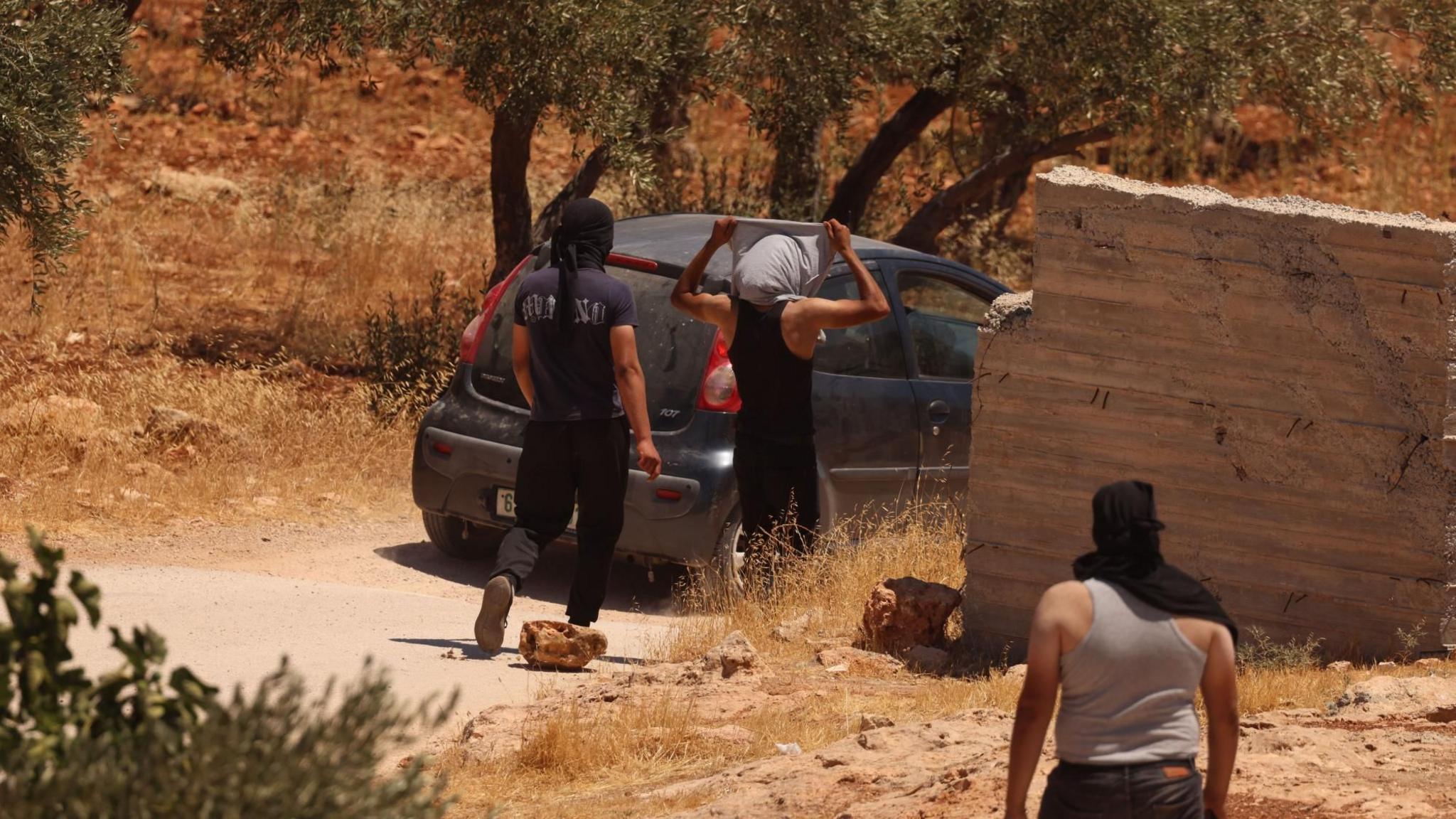 Image caption,Palestinian residents of al-Mughayyir confront Israeli settlers and troops