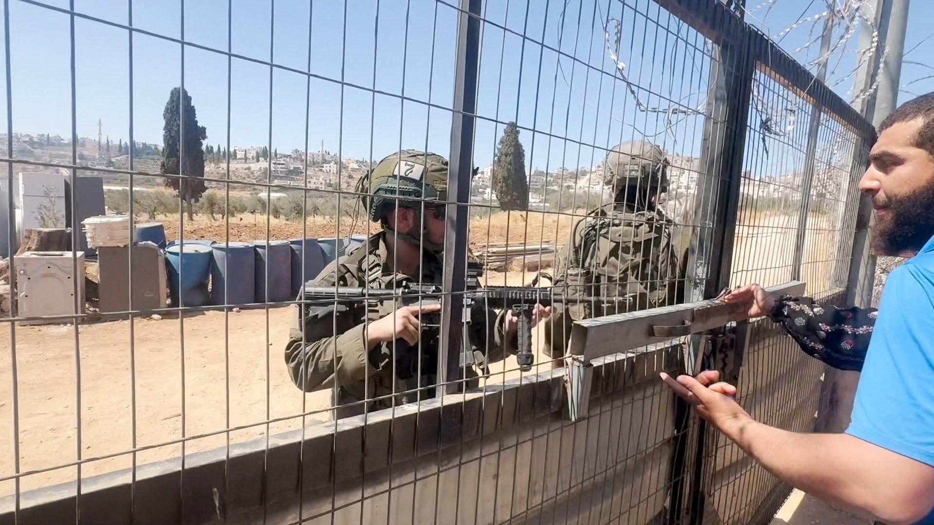 Image caption,Footage appeared to show Israeli soldiers making no attempt detain the settlers who attacked the Abu Alia compound or confiscate their clubs