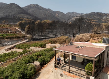 Mechanic Vicent Barres, 55, posing at the entrance of his house, which remained untouched by wildfires despite nearby land being scorched, in the village of La Vilavella, Castellon province.Photograph: Nacho Doce/Reuters