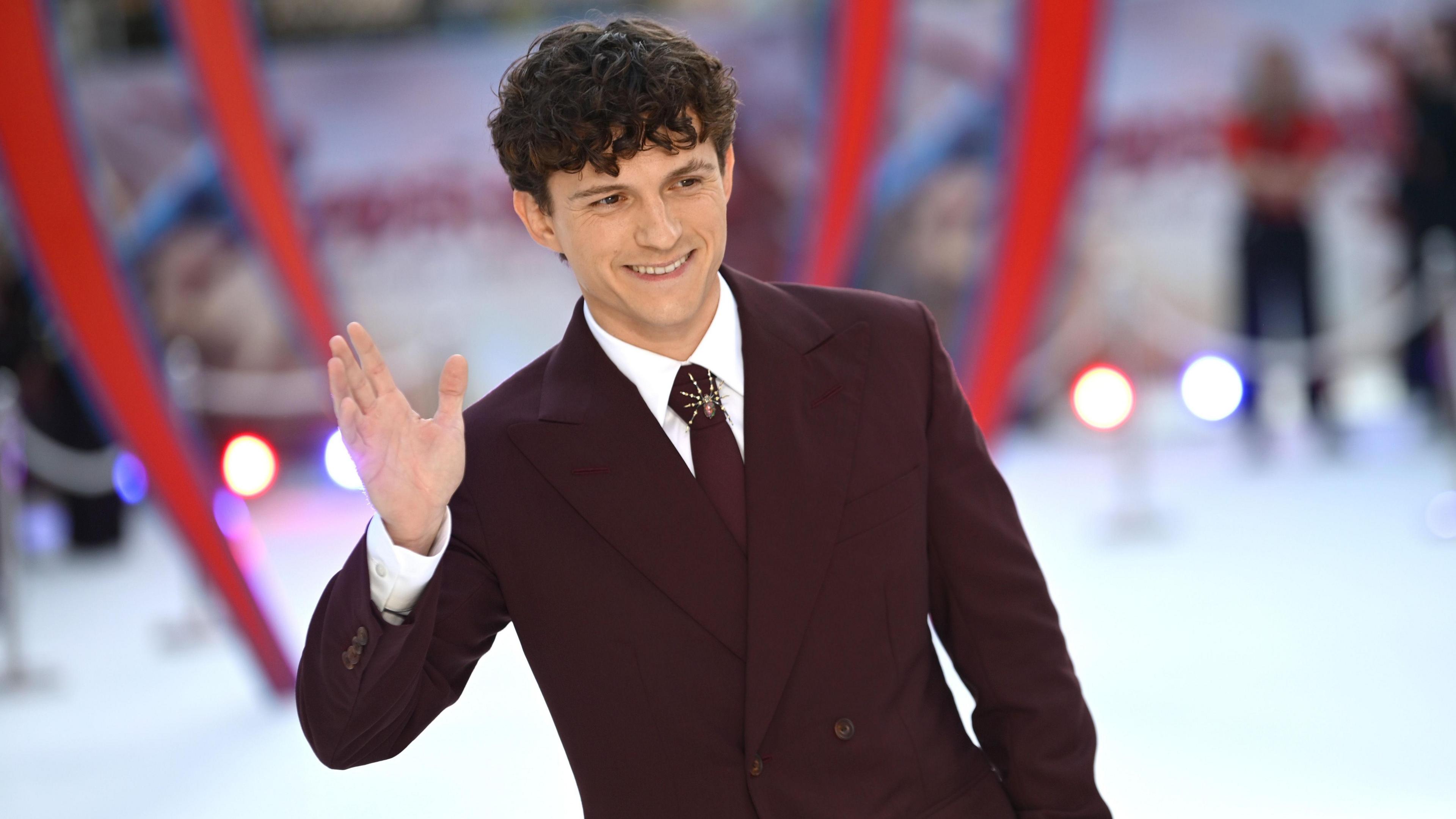 Image caption,Tom Holland, who plays Spider-Man, wore a burgundy Louis Vuitton suit and spider brooch