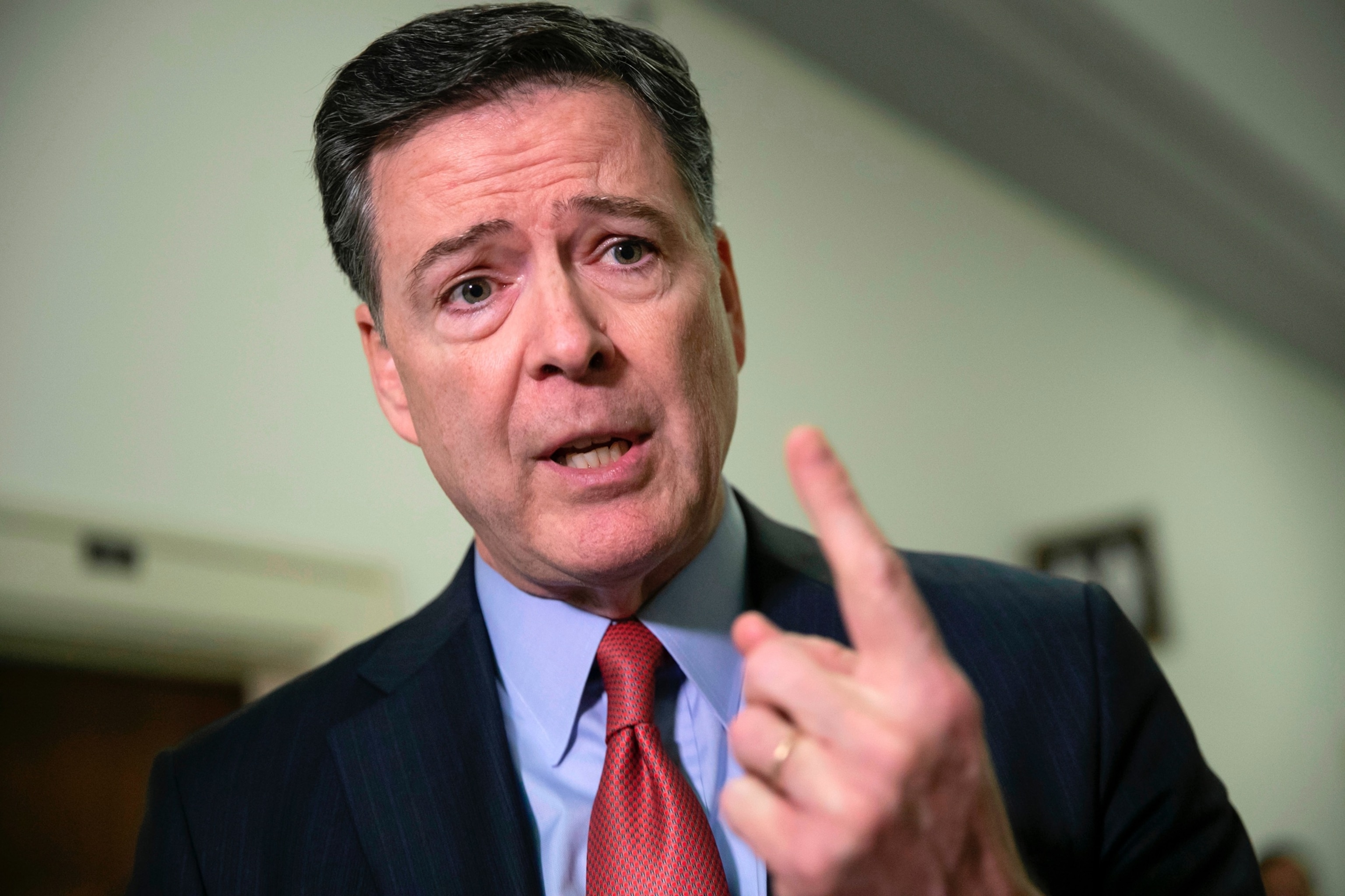 FILE - Former FBI Director James Comey speaks to reporters on Capitol Hill in Washington, Dec. 17, 2018.J. Scott Applewhite/AP