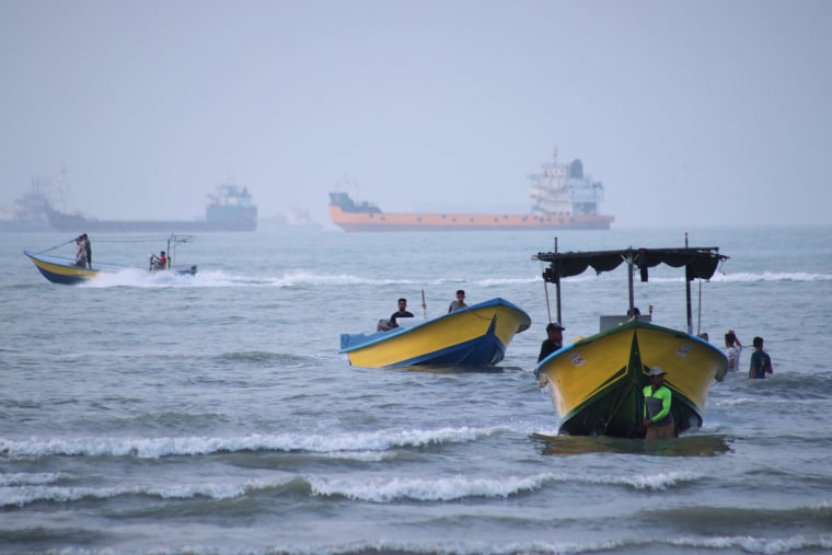 Small boats line the shore as cargo ships and other vessels anchor in the Strait of Hormuz, off Bandar Abbas, Iran, on Monday.Razieh Poudat / AP