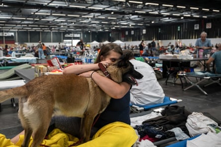 An evacuated woman with her dog in the exhibition centre in Bordeaux.Photograph: Ed Jones/AFP/Getty Images