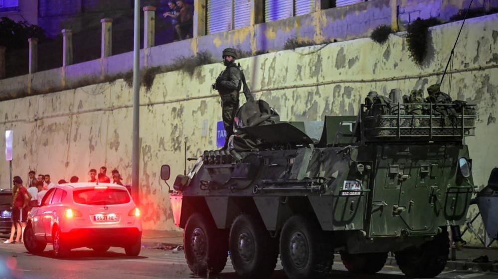 Image caption,Spanish military stands guard at the border between the Spanish enclave of Ceuta and Morocco