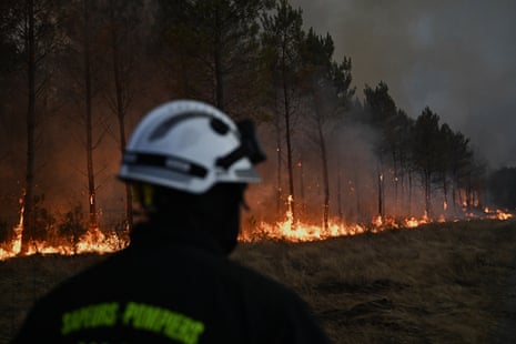 A firefighter walks in front of burning trees as a wildfire rages near Marcheprime, outside Bordeaux.Photograph: Emma Da Silva/AP