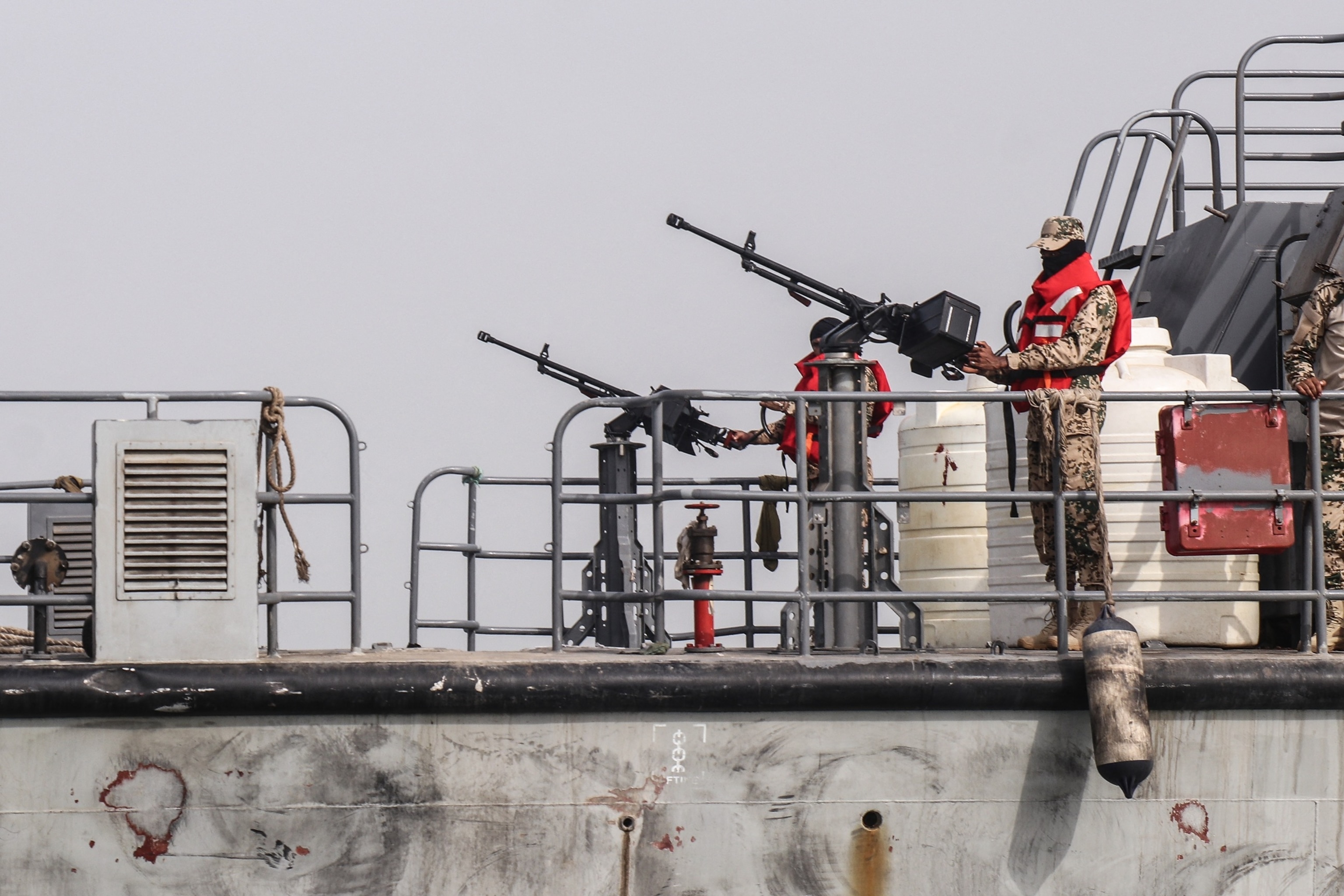 Sailors from the navy of Yemen's Aden-based internationally recognized government stand at machine gun positions aboard a vessel patrolling a shipping lane off Hanish Island in the Red Sea on July 27, 2026.Khaled Ziad/AFP via Getty Images