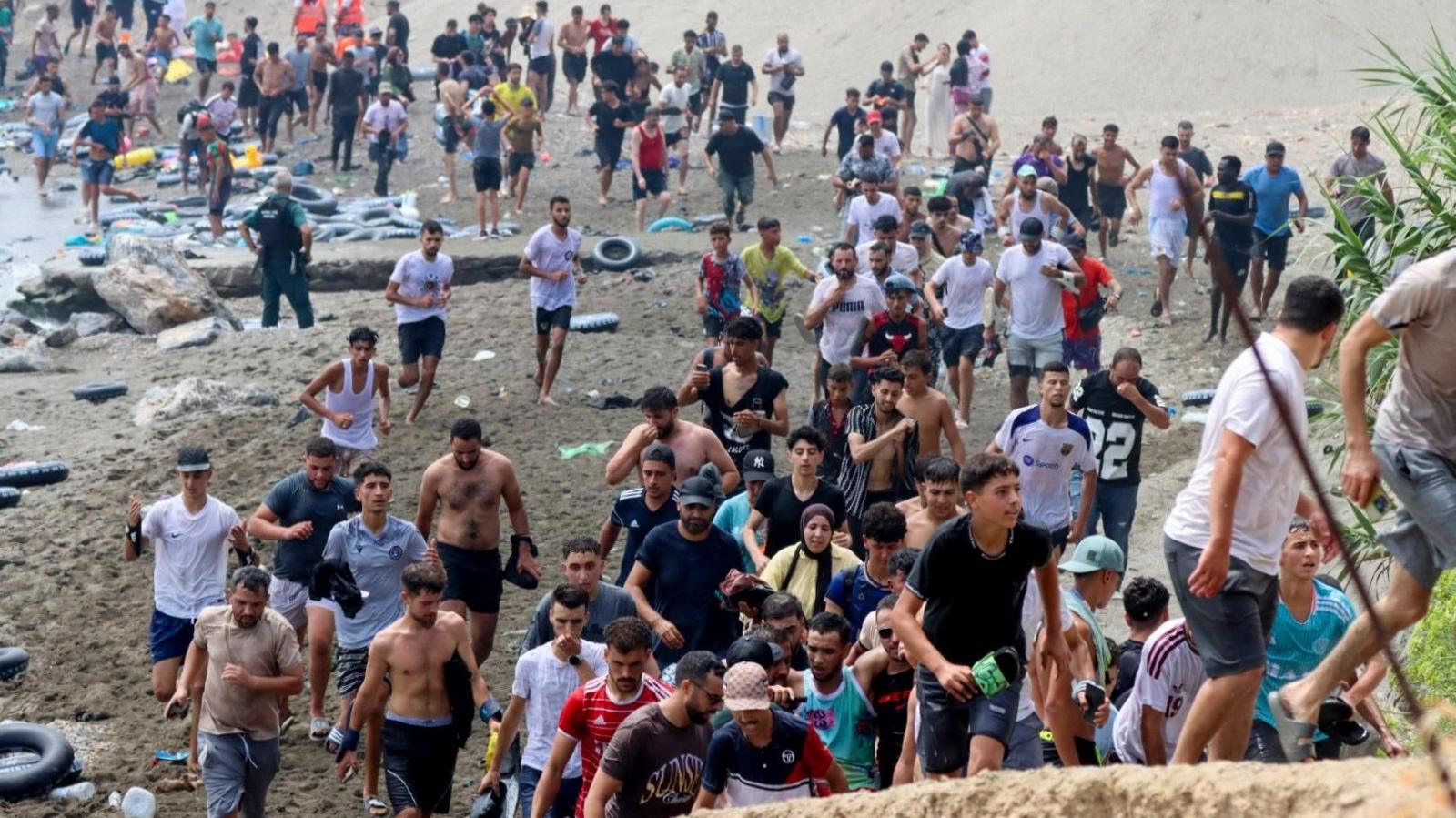Image caption,Many young men were seen swimming into Ceuta or crossing the land border