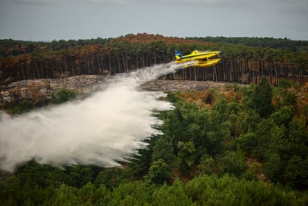 A firefighting plane drops water on the wildfire near Le Porge. The village was evacuated when burning cinders fell from the sky.Photograph: Sarah Meyssonnier/Reuters