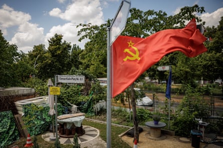 Tongue-in-cheek Nato and Soviet flags whip from erected poles outside the treehouse.Photograph: Gordon Welters/The Guardian