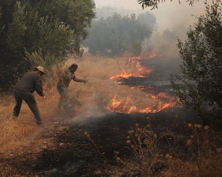 A firefighting helicopter drops water over a forest near Porto Germeno, north-west of Athens, on Sunday.Photograph: Michael Varaklas/AP