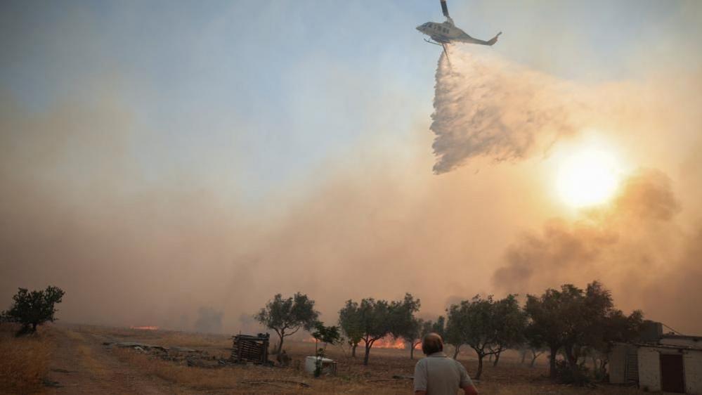 Image caption,Firefighters and forensic experts were later seen working at the crash site