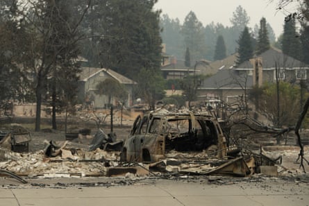 A vehicle and structure are burned on N Skyline Dr due to a wildfire on 2 August in Spokane, Washington.Photograph: Young Kwak/AP