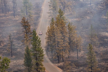 A vehicle drives by as smoke billows from the Old Trails fire as wildfires burn in Spokane, Washington, on 2 August.Photograph: David Ryder/Reuters