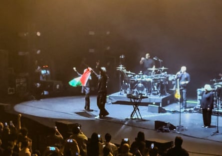 Robert Del Naja and Grant Marshall from Massive Attack stand with a Palestinian flag at the end of their performance in Singapore on 29 July.Photograph: Simran Panaech/Reuters