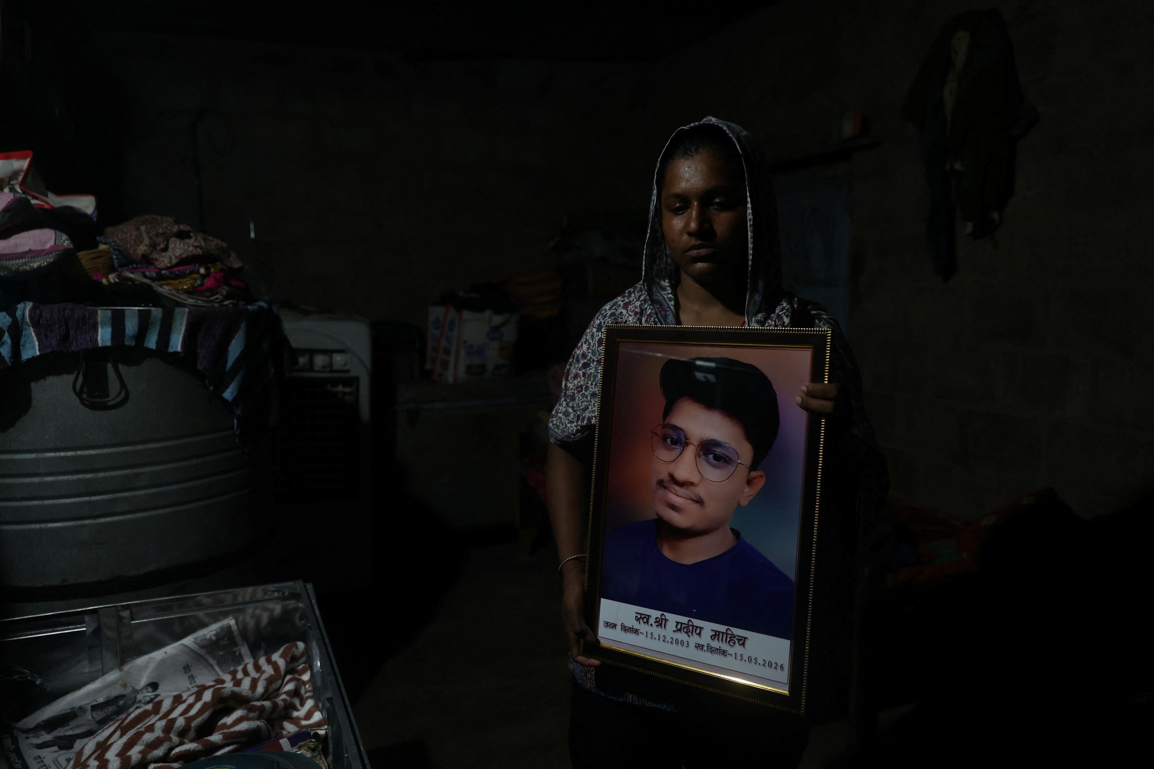Image caption,Babita Kumar holds a photograph of her brother, Pradeep Kumar, who took his own life before the NEET retest