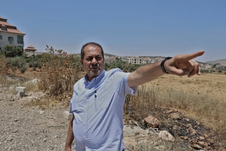 Yaser Alkam, the head of the village council, who lived in the US for 35 years, shows the ‘hot areas’ where radical settlers attack Palestinian landowners.Photograph: Quique Kierszenbaum/The Guardian