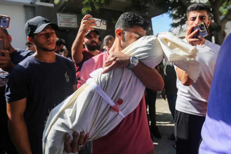 Family and friends mourn a victim killed in an Israeli airstrike, at Al-Shifa Hospital on Sunday, in Gaza City.Ahmad Hasaballah / Getty Images