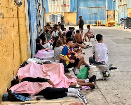 People who crossed from Morocco sit on a street in Ceuta on Monday.Photograph: Reduan/EPA