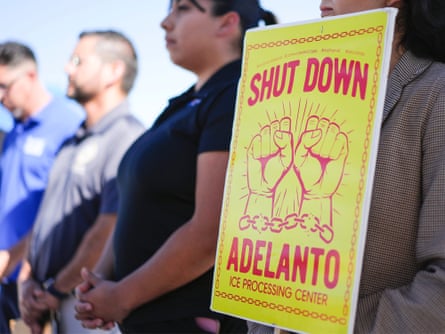 A woman holds a sign calling for the closure of the Adelanto center.Photograph: Jay Calderon/Desert Sun/USA Today/Reuters