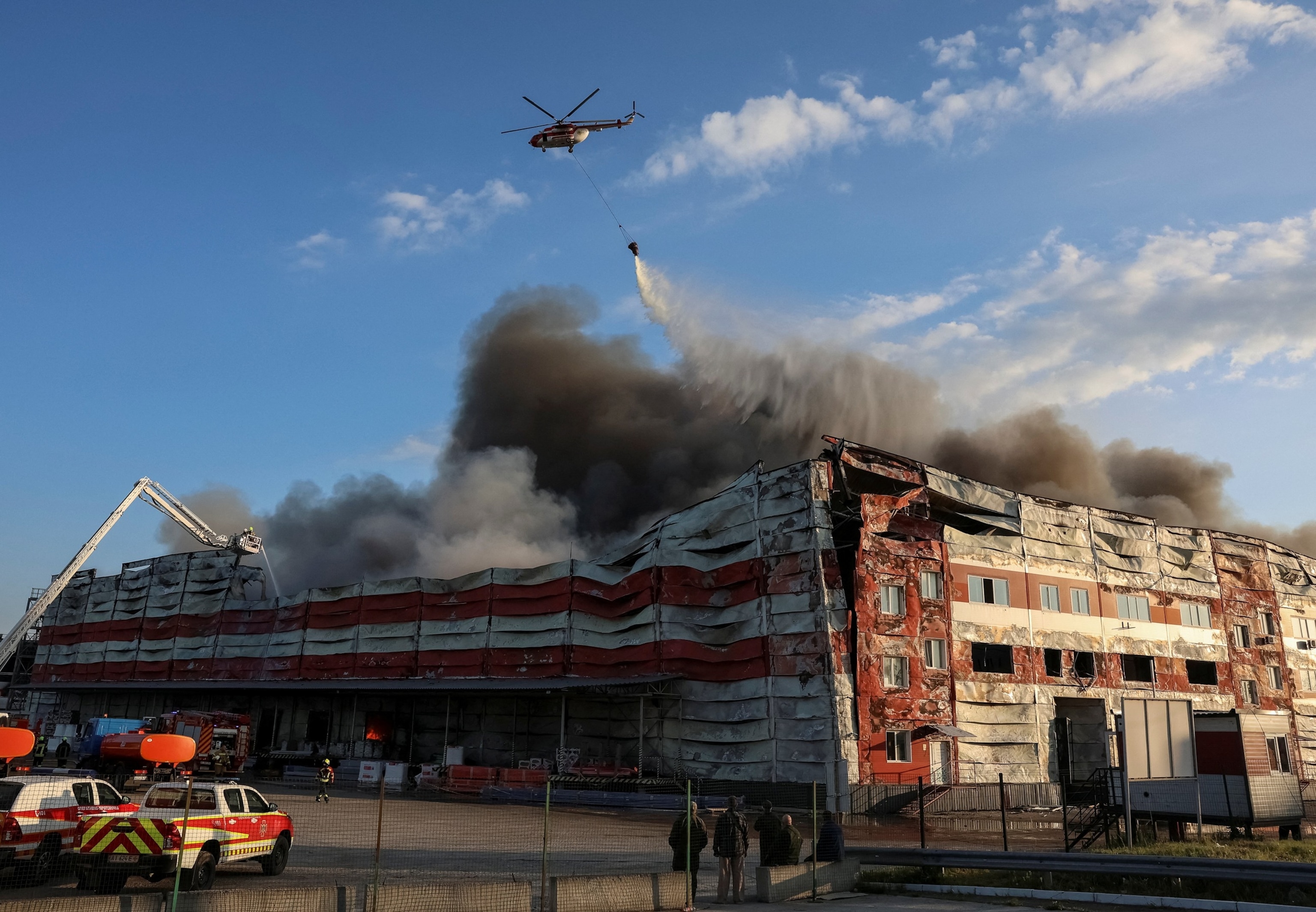 A firefighting helicopter drops water over the site of a Russian missile strike in Kyiv region, Ukraine, on July 19, 2026.Anatolii Stepanov/Reuters