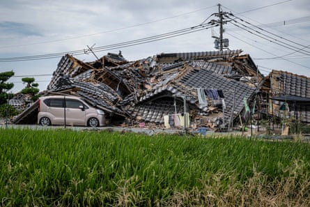 A house is seen collapsed onto a car in Hikawa.Photograph: AFP/Getty Images
