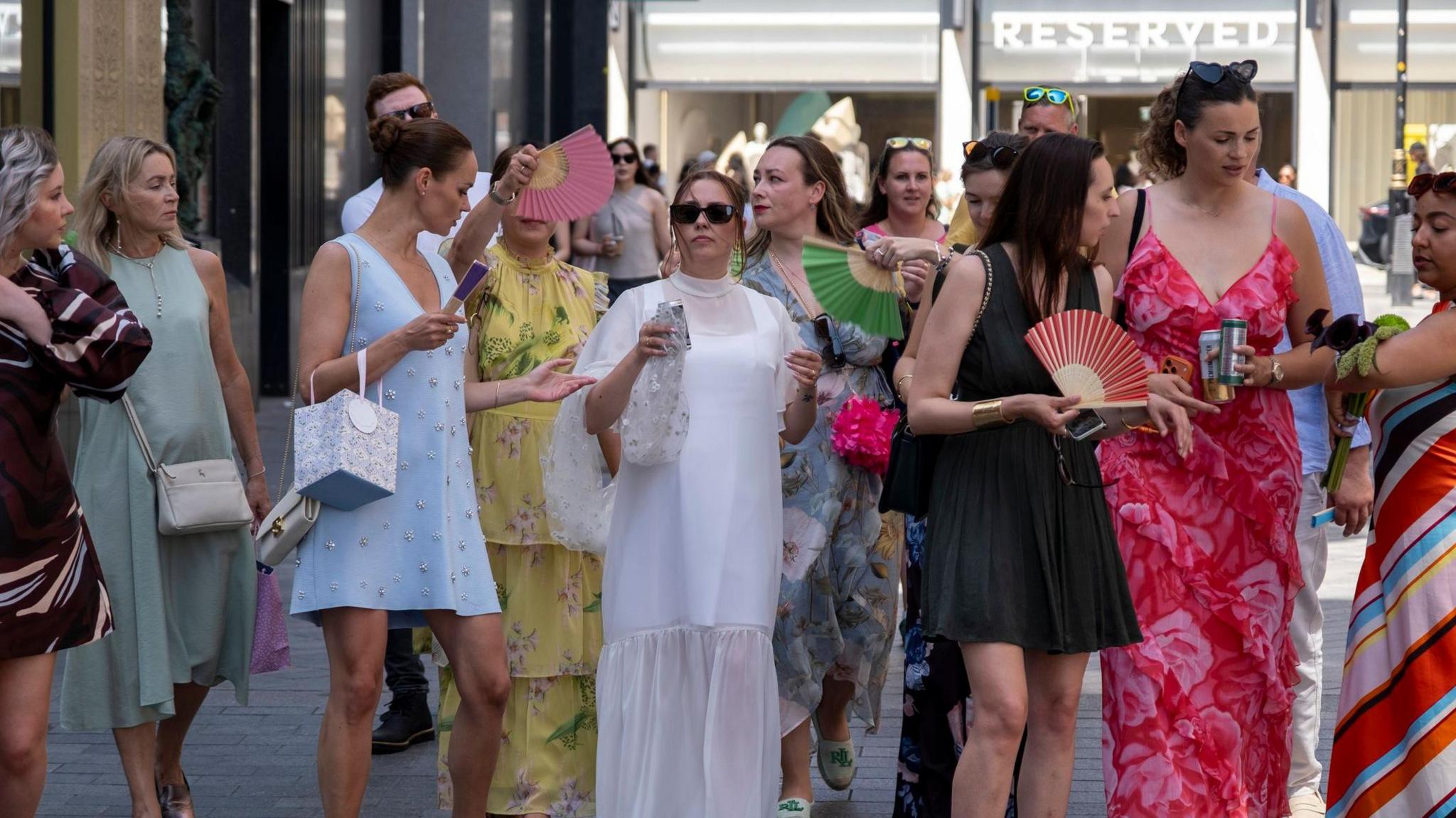 Image caption,Sales for wedding fans have increased as couples and guests try and keep themselves cool