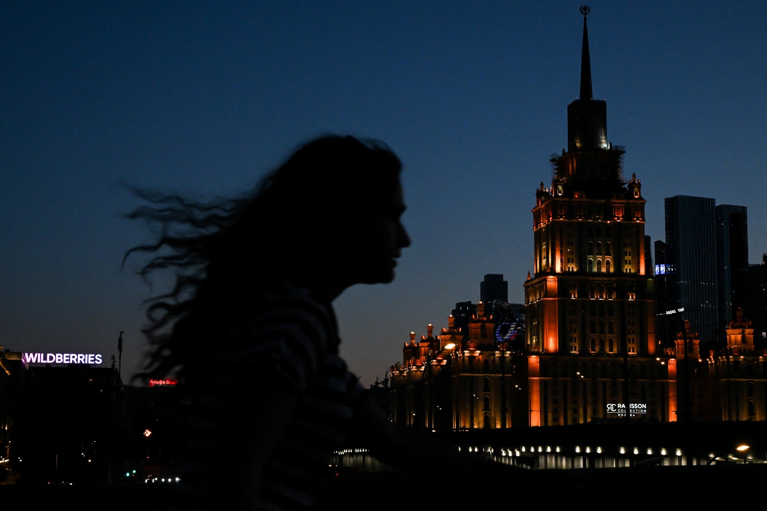 A pedestrian walks along the street past a "Wildberries" signboard the "Ukraina" hotel in central Moscow on August 3, 2026.Igor Ivanko/AFP via Getty Images