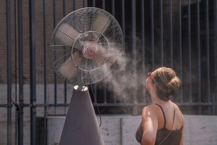 A tourist cools down from a misting fan in Rome.Photograph: Amer Ghazzal/Shutterstock