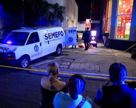 Onlookers stand behind a police cordon at the scene of César Gastélum’s killingPhotograph: Jesús Bustamante/Reuters