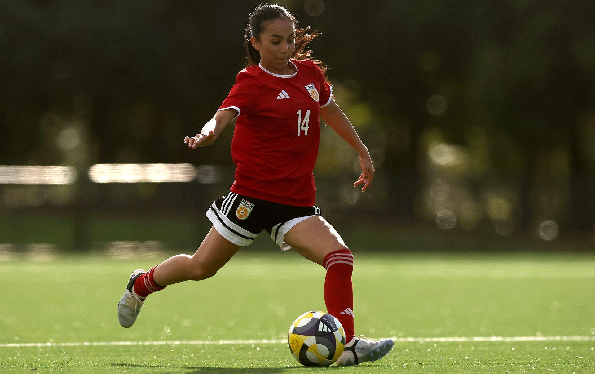 Image caption,Najma Arefi, pictured during one of the matches against the Cook Islands, moved to the UK after the Taliban returned to power