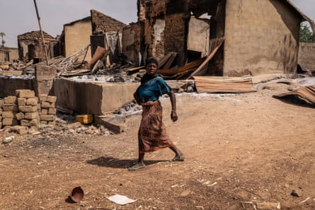 A woman walks past debris, burnt structures and damaged shops after the February attack on Woro.Photograph: Light Oriye Tamunotonye/AFP/Getty Images