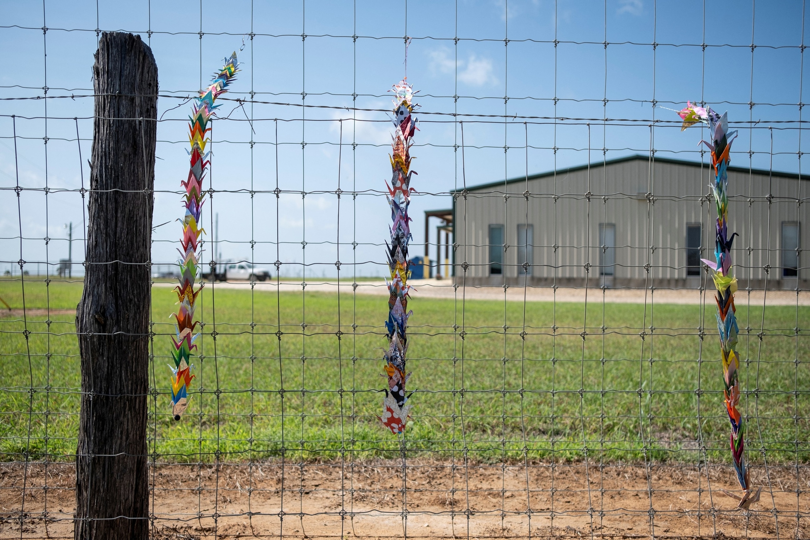 Origami cranes are pinned on fencing outside the South Texas Family Residential Center in Dilley, Texas, June 27, 2026.Joel Angel Juarez/Reuters