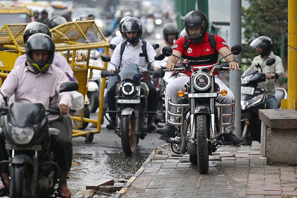 Image caption,Motorcyclists riding on a pedestrian footpath along a bridge in Delhi